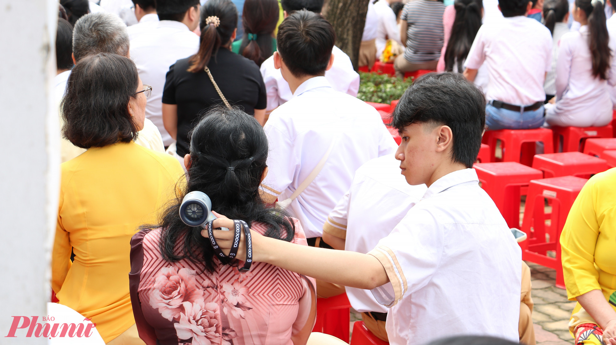 Con trai tinh tế cầm quạt cho mẹ giữa trời nắng