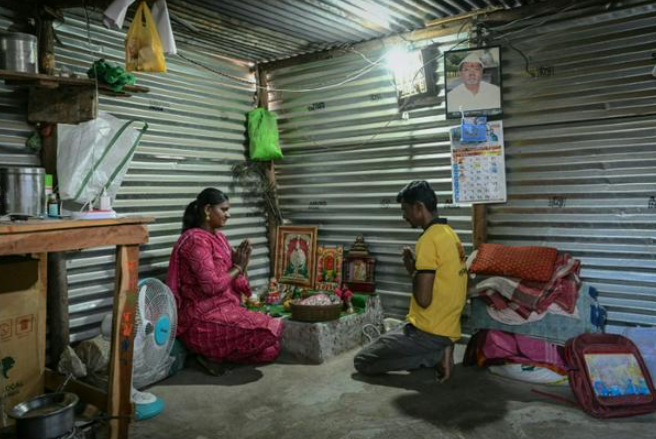 Jyoti Thorat (trái), một công nhân mía đường kết hôn khi còn là cô dâu trẻ, cầu nguyện cùng chồng, Ravindra, tại nhà riêng ở làng Kathoda, quận Beed, bang Maharashtra, Ấn Độ © Indranil MUKHERJEE / AFP