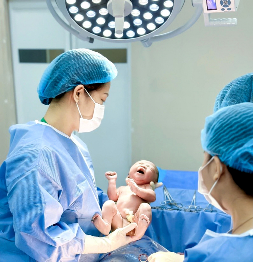 Lợi dụng cổ xúy sinh con thuận tự nhiên để bán hàng, lừa đảo Bác sĩ Nguyễn Thị Thu Hà (trái) cùng đồng nghiệp chào đón một em bé sơ sinh. Em bé được cắt dây rốn ngay khi ra khỏi bụng mẹ để tránh nhiễm trùng - Ảnh do nhân vật cung cấp