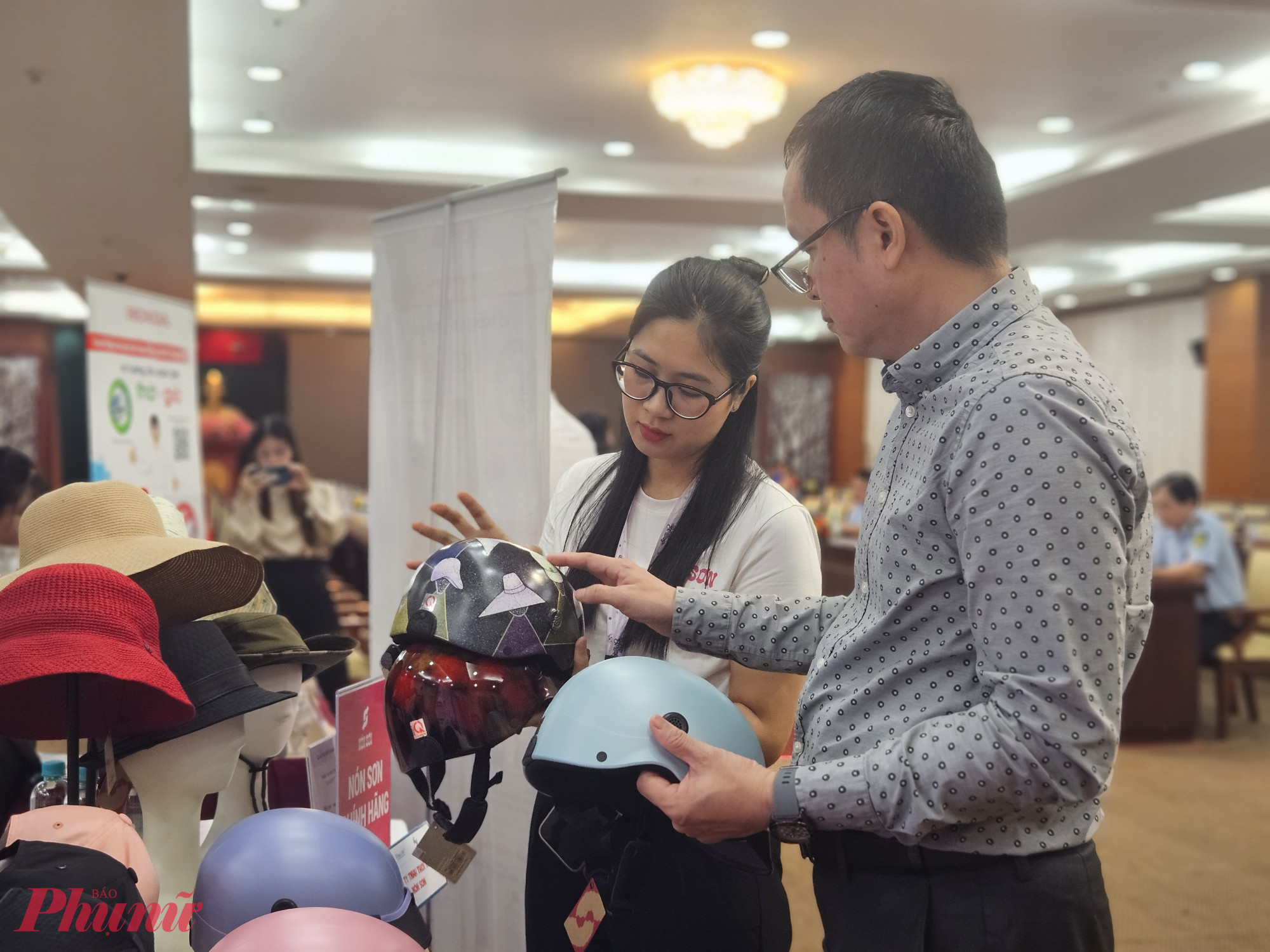 Nhân viên công ty thời trang Nón Sơn hướng dẫn người tiêu dùng phân biệt nón thật với nón giả - Ảnh: Ngọc Thùy