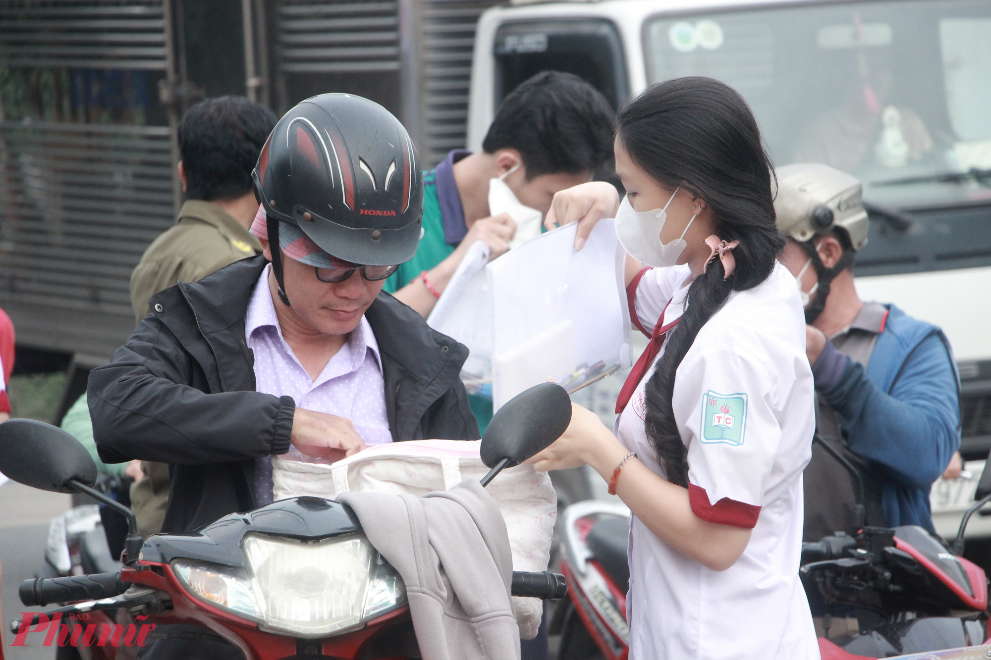 Phụ huynh chở các thí sinh tới điểm thi, không quên dặn dò và chúc con thi tốt - Ảnh: Nguyễn Loan
