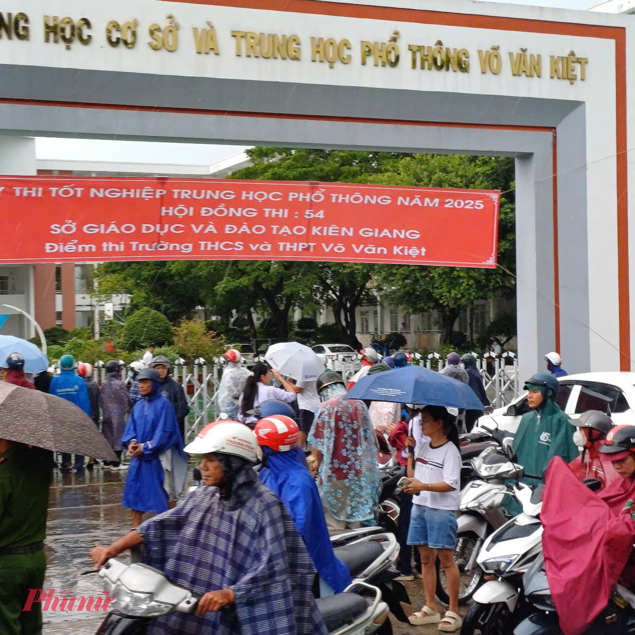 Phụ huynh mặc áo mưa, cầm ô đợi con thi môn văn ở Rạch Giá - Ảnh Phú Hữu