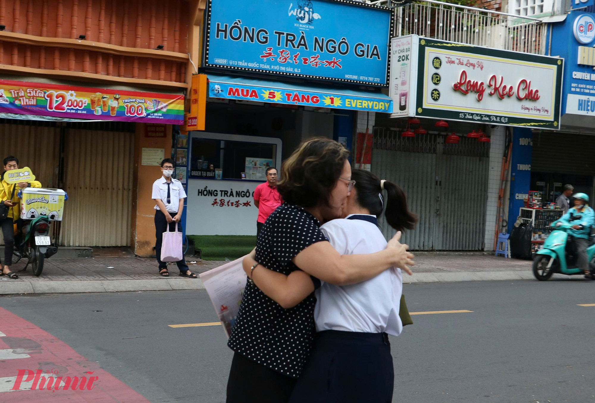 Một phụ huynh ôm động viên con sau khi con đã hoàn thành bài thi môn đầu tiên - Ảnh: Trang Thư