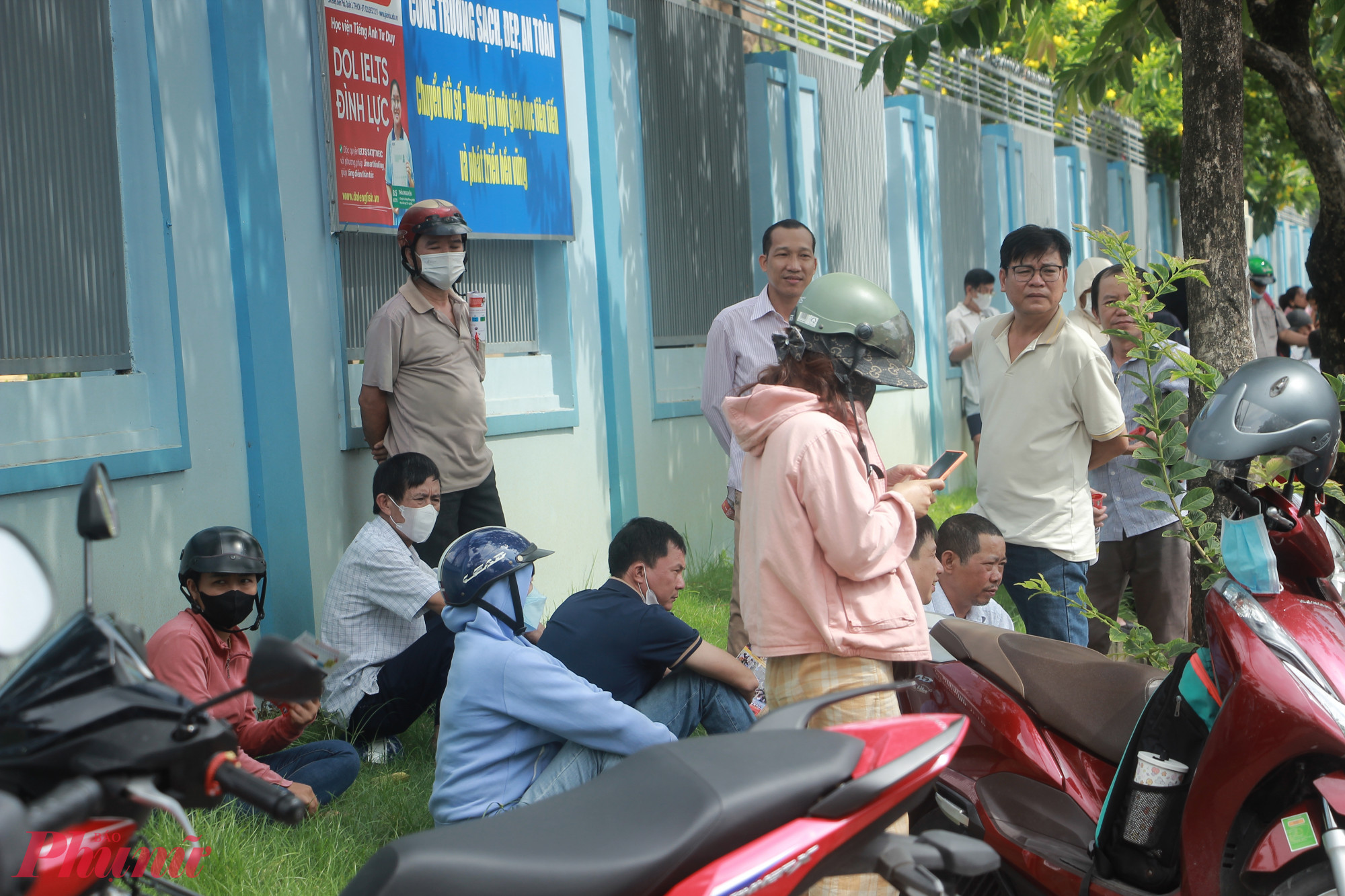 Nhiều phụ huynh ngồi vật vạ ngoài điểm thi đề chờ con - Ảnh: Nguyễn Loan