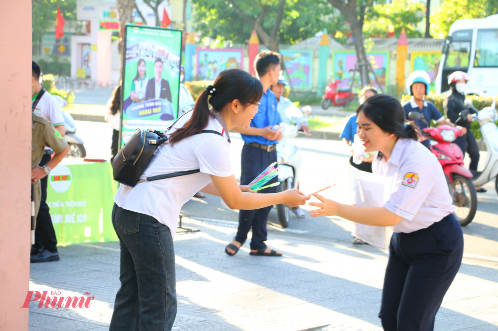 Từ sáng sớm lực lượng tình nguyện viên đã có mặt tại cổng trường triển khai các điểm “ tiếp sức viết” cho thí sinh.