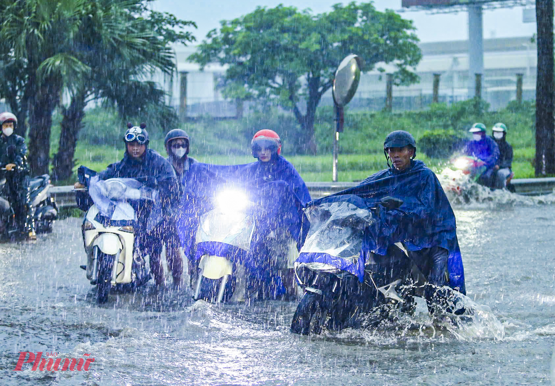 Người dân chật vật tiến không được, lùi cũng chẳng xong khi đứng giữa dòng nước ngập.