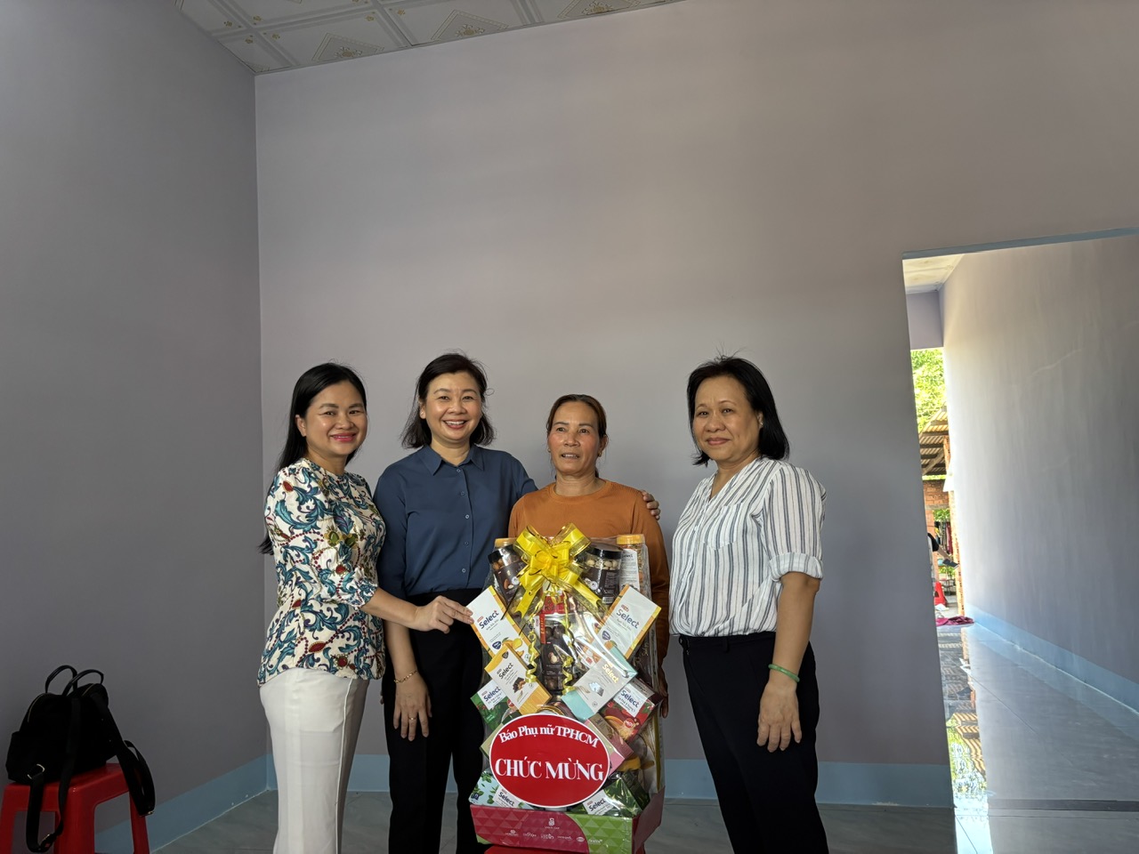 Lãnh đạo Báo Phụ nữ TPHCM tặng quà cho bà Nguyễn Thị Để.