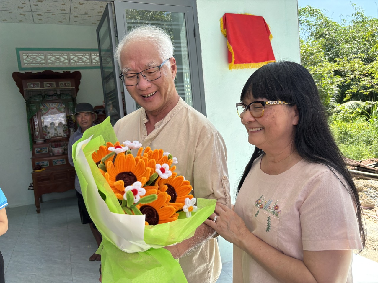 Vợ chồng ông bà Phan Đình Huy nhận bó hoa tri ân từ lãnh đạo địa phương.