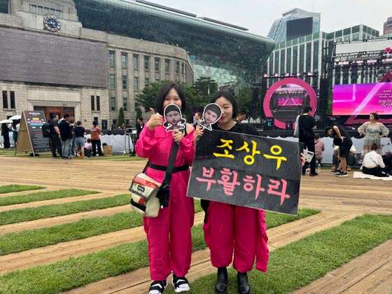Khán giả mặc trang phục Pink Guard từ bộ phim ″Squid Game″ (2021-) của Netflix, tạo dáng chụp ảnh trong sự kiện