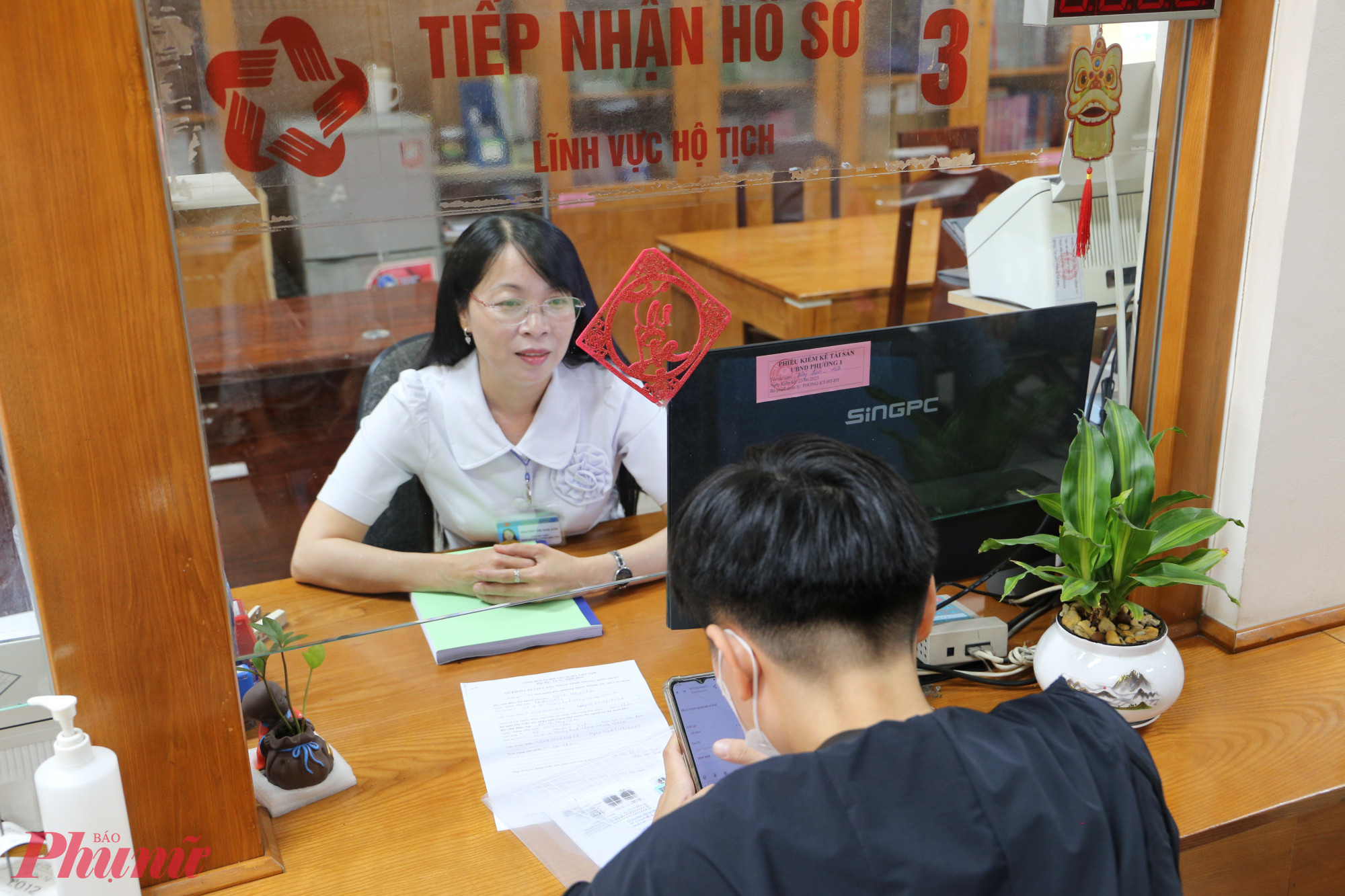 Chị Nguyễn Thị Kim Ánh – công chức tư pháp, hộ tịch – tận tình tiếp nhận hồ sơ người dân trong buổi sáng đầu tiên - Ảnh: Thanh Tâm