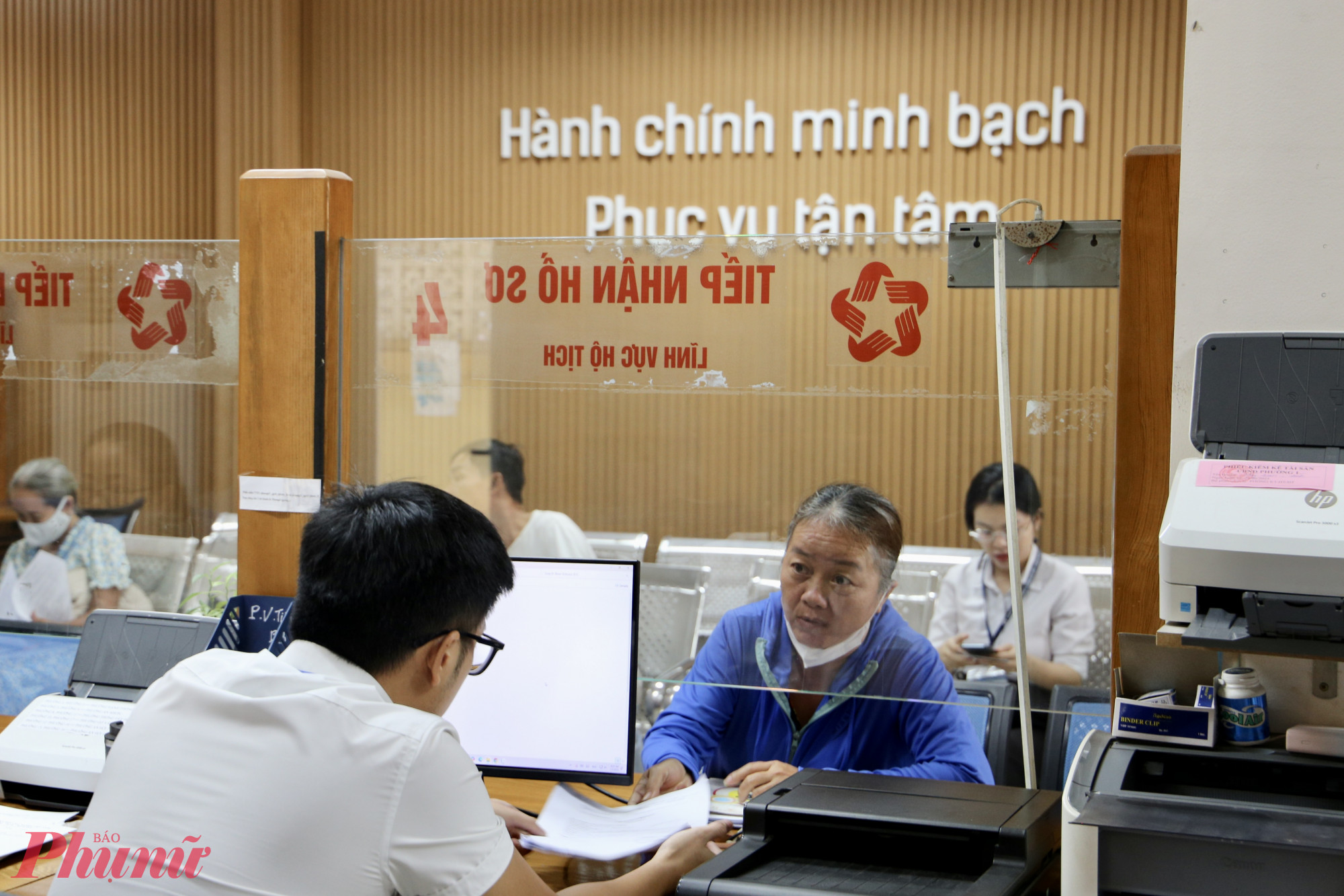 Cán bộ phường Hạnh Thông hỗ trợ người dân kê khai thông tin ngay tại quầy tiếp nhận hồ sơ - Ảnh: Thanh Tâm