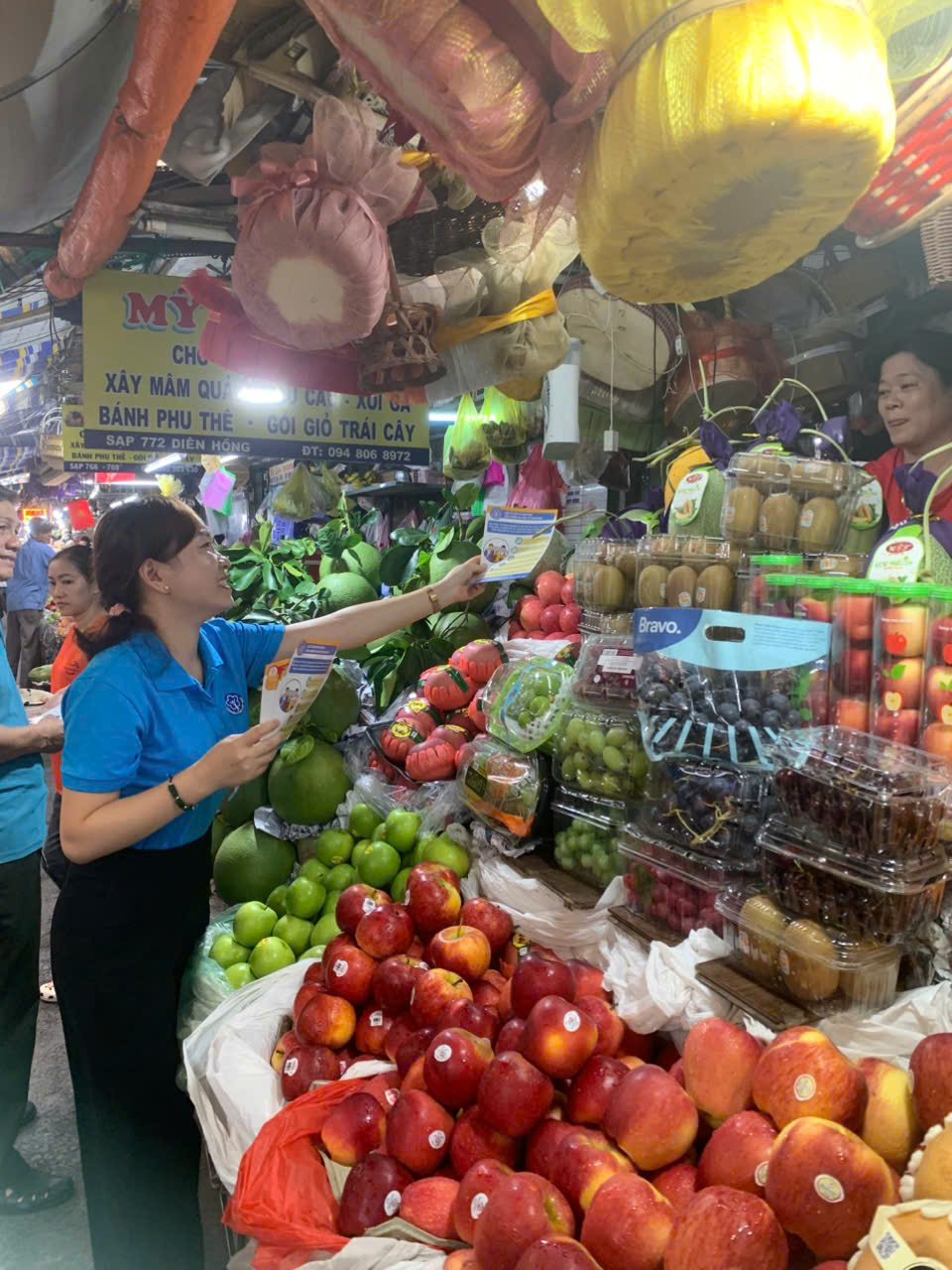 BHXH quận Bình Thạnh phối hợp Ban Quản lý Chợ Bà chiểu để phát tờ truyên truyền đến các tiểu thương