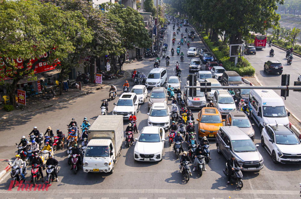 Người dân dừng đèn đỏ tại ngã tư đường Láng (Hà Nội) - Ảnh: Anh Ngọc