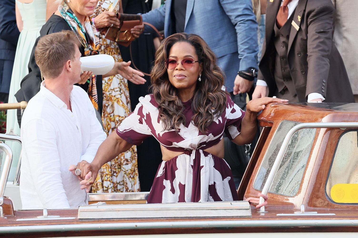 Khi lễ cưới hoá sàn diễn thời trang Oprah Winfrey gây chú ý với phong cách sang trọng nhưng vẫn phóng khoáng, toát lên khí chất của một biểu tượng truyền thông quyền lực. Bà chọn chiếc váy dáng dài với tông màu mận chín nổi bật, điểm họa tiết trắng in lớn tạo hiệu ứng thị giác ấn tượng