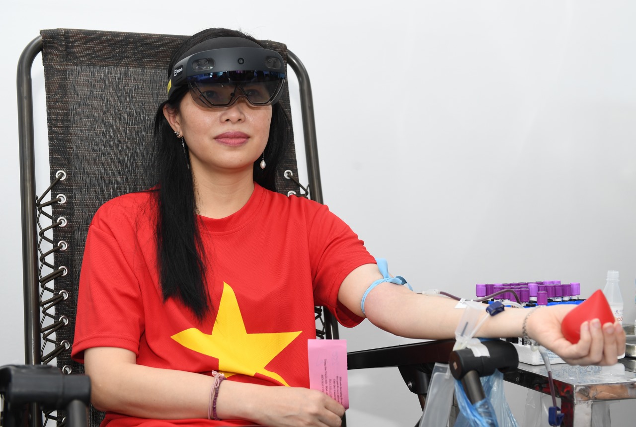 Chị Đoàn Thị Thanh Thủy trải nghiệm hiến máu khi đang đeo kính thực tế ảo tích hợp - Ảnh: Hoàng Anh