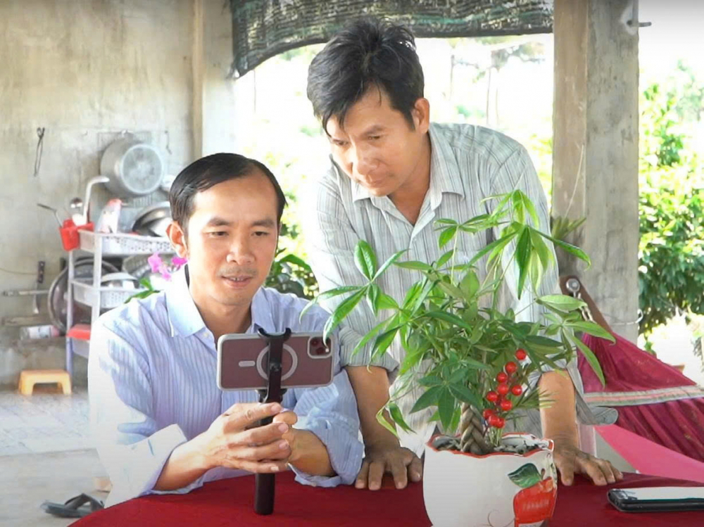 Tích cực số hóa để sản phẩm làng nghề vươn xa Anh Nguyễn Trúc Linh (bìa trái) - nông dân làng mai Bình Lợi, TPHCM - hướng dẫn các nông dân khác quay video quảng bá sản phẩm - ẢNH: THU LÊ