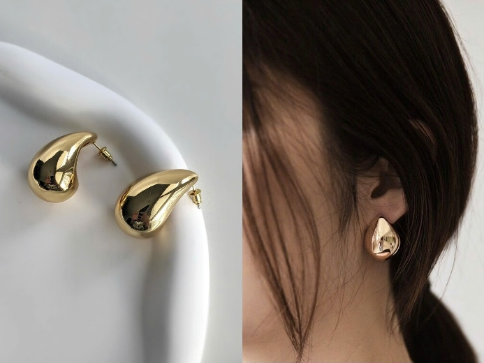 Bông tai ánh kim dáng giọt nước với thiết kế bản lớn, cùng bề mặt ánh kim mang đến cho bạn cảm giác hiện đại và vẫn giữ được sự mềm mại nhờ đường nét bo tròn nhẹ nhàng. Kiểu bông này phù hợp với những trang phục tối giản, gam trung tính và đơn sắc, giúp bạn tạo điểm nhấn mà không làm rối tổng thể. Hãy thử phối cùng sơ mi cổ cao, váy suông và áo hai dây trơn đều có thể mang lại sự nổi bật, phù hợp cả khi đi làm lẫn dự tiệc nhỏ.