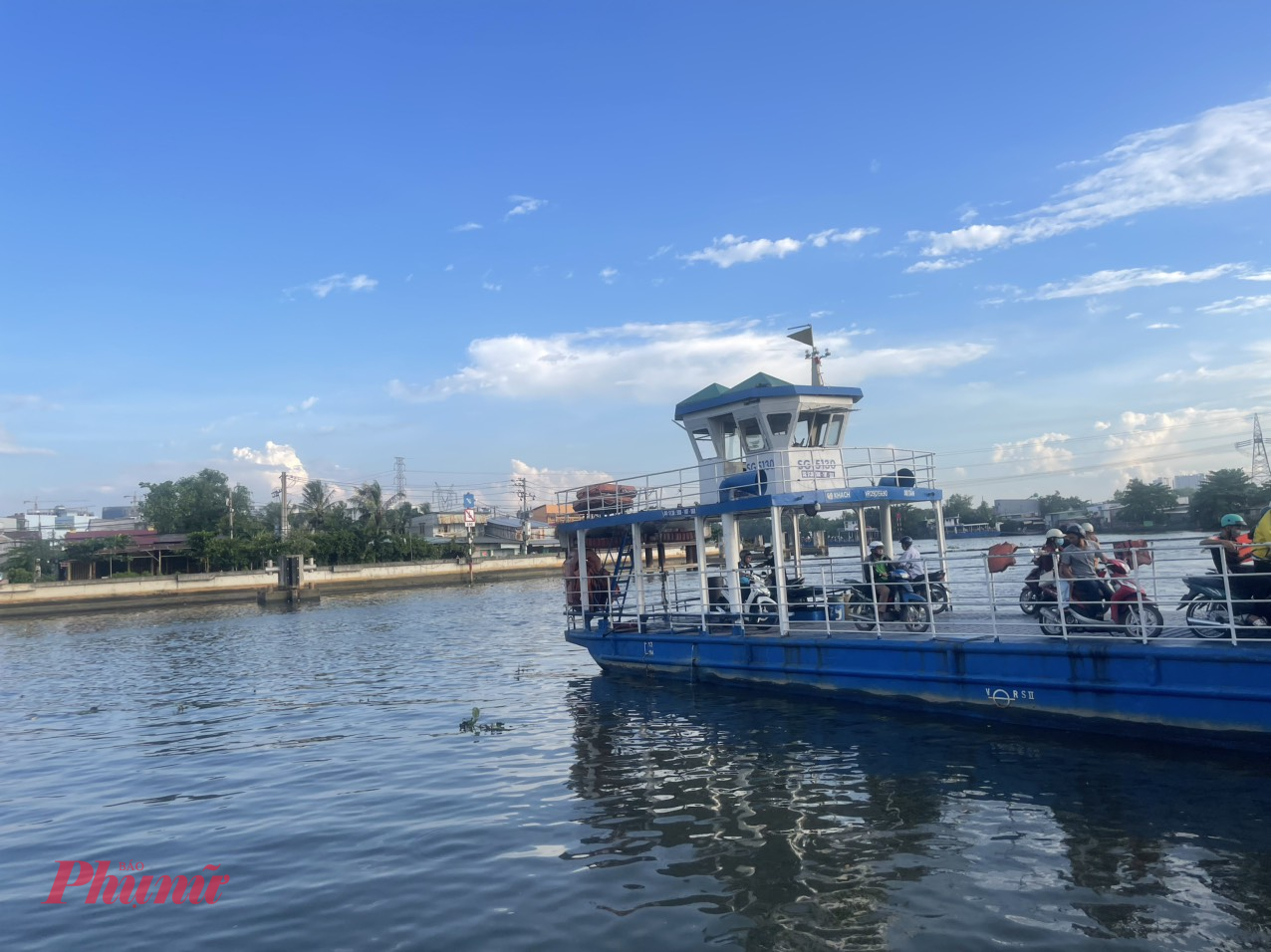 Phà Phú Định – nơi dòng kênh mang ký ức chạy dài Thuộc phường Phú Định (quận 8 mở rộng), khu vực bến phà Phú Định chẳng xa lạ gì với người dân sống lâu năm ở khu Tây Sài Gòn. Nhưng nếu bạn là một cư dân đô thị quen sống trong các toà cao tầng, một sáng về đây đứng trên bờ kênh, nghe sóng vỗ lách tách, nhìn chiếc phà lắc lư qua dòng nước và cảm nhận đời sống mộc mạc hai bên bờ, ắt sẽ thấy lòng mình dịu lại.  Phà Phú Định nối đôi bờ quận 8 và huyện Bình Chánh, có mặt từ thời Pháp thuộc và từng là huyết mạch vận chuyển hàng hóa, nhu yếu phẩm cho vùng ven. Giờ đây, phà chủ yếu chở người dân qua lại, nhưng quanh bến vẫn nhộn nhịp cảnh buôn bán, quán cóc cà phê, tiệm hớt tóc vỉa hè và những xe bánh mì nóng giòn mỗi sáng.  Đi thêm 2 km, bạn sẽ gặp Đình Phú Định, một ngôi đình cổ hơn 100 năm tuổi – nơi lưu giữ dấu ấn của làng Phú Định xưa. Đình thờ Thành hoàng và các vị tiền hiền, được công nhận di tích lịch sử cấp thành phố. Mỗi dịp lễ Kỳ yên, người dân tụ hội về đây, dâng hương và tổ chức hát bội – một nét văn hóa dân gian còn sót lại giữa lòng đô thị đang thay da đổi thịt.