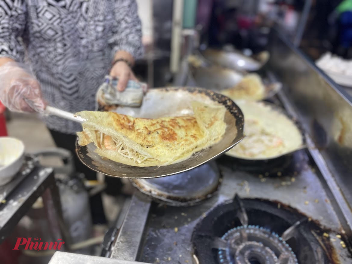 Bánh xèo, cá nướng – ăn đặc sản miền Tây giữa lòng TPHCM Nằm ở cửa ngõ phía Nam thành phố, các phường như Hưng Long và An Phú Tây (thuộc quận Bình Chánh mới) vẫn còn lưu giữ được nét ẩm thực đặc trưng của vùng sông nước. Không cần đi xa tận Tiền Giang, Long An hay Bến Tre, chỉ cần rẽ vài con đường nhỏ ở khu vực này, bạn đã có thể thưởng thức đủ món ngon đúng chuẩn miền Tây.  Đầu tiên phải kể đến bánh xèo An Phú Tây – món bánh xèo giòn tan với nhân tôm đất, giá đỗ và thịt ba rọi, ăn kèm rau vườn và nước mắm pha ngọt thanh. Tại một số quán trong hẻm Ấp 1 hoặc gần chợ An Phú Tây, món bánh xèo được đúc trên bếp than, vừa nóng hổi vừa thơm lừng mùi nghệ và nước cốt dừa.  Còn nếu bạn yêu thích món nướng đồng quê, hãy ghé chợ Hưng Long, nơi nổi tiếng với các quầy cá lóc nướng trui than rơm, phục vụ ngay tại chỗ. Con cá vàng ươm, được dập đầu, giữ nguyên vảy, nướng nguyên con trên bếp than rực hồng. Khi ăn, người bán sẽ cạo sạch lớp vảy cháy, lật phần thịt trắng ngần ra, ăn cùng bánh tráng, bún, rau sống và chén mắm me sền sệt. Một trải nghiệm đậm chất quê giữa lòng đô thị. Gợi ý lịch trình “du hí phường mới” một ngày cuối tuần