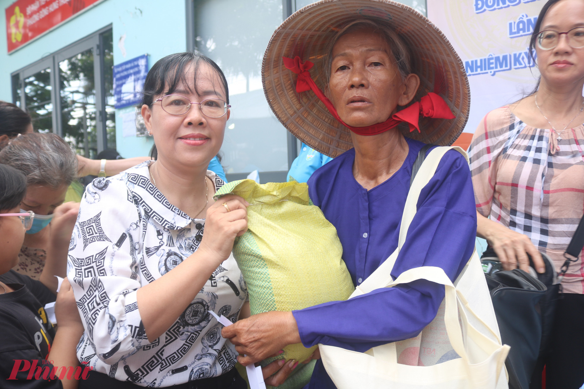 Bà Nguyễn Ngọc Yến (bìa trái) – Phó chủ tịch Uỷ ban Mặt trận Tổ quốc, Chủ tịch Hội LHPN phường Đông Hưng Thuận, TPHCM – trao những túi gạo đến tay người dân. 