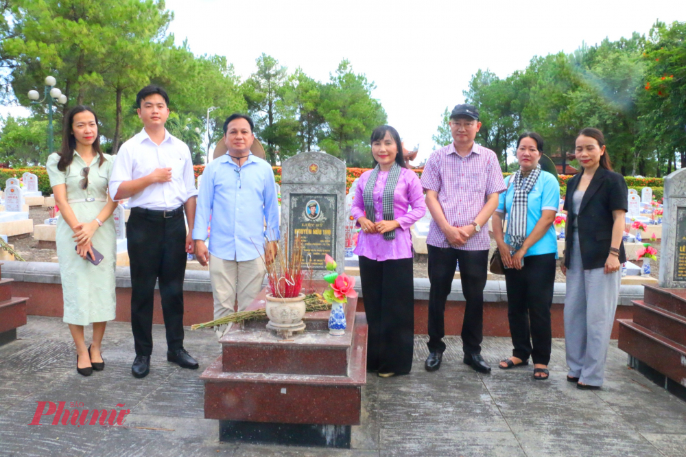 Đoàn công tác chụp hình lưu niệm bên một phần các liệt sĩ