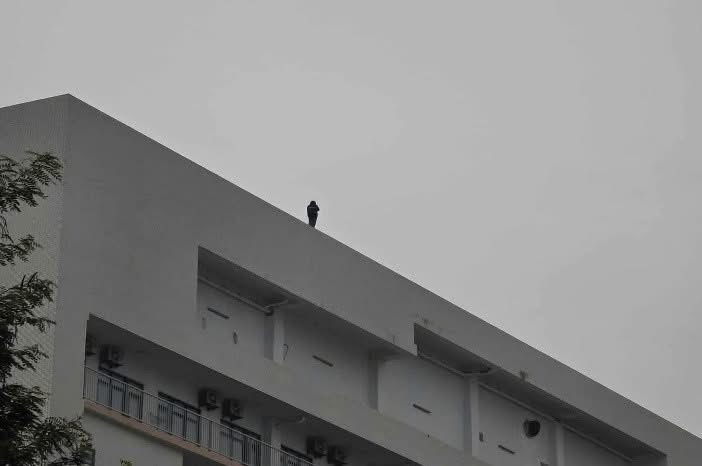 Nạn nhân đứng trên nóc tòa nhà K1 với ý định tự tử. Ảnh Công an Hà Nội.