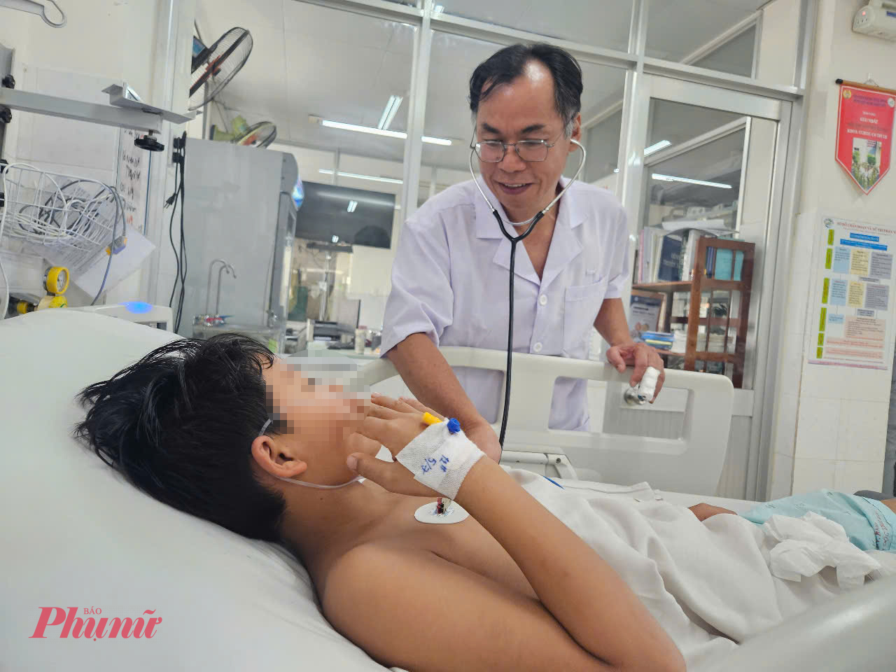 Bác sĩ Phan Tứ Quí thăm khám cho bé trai mắc sốt xuất huyết biến chứng viêm gan được khoa điều trị qua nguy kịch, ảnh Phạm An