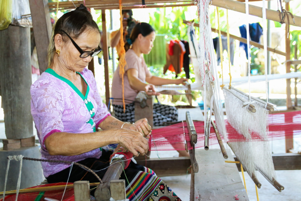 Những phụ nữ lớn tuổi ở bản Hoa Tiến miệt mài bên khung cửi - ẢNH: PHAN NGỌC