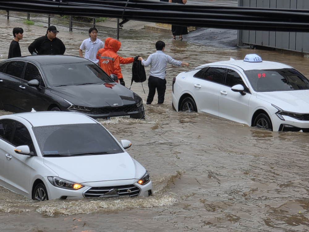 Ô tô bị ngập trong nước lũ tại quận Buk, thành phố Gwangju, ngày 17/7 - Ảnh: YONHAP