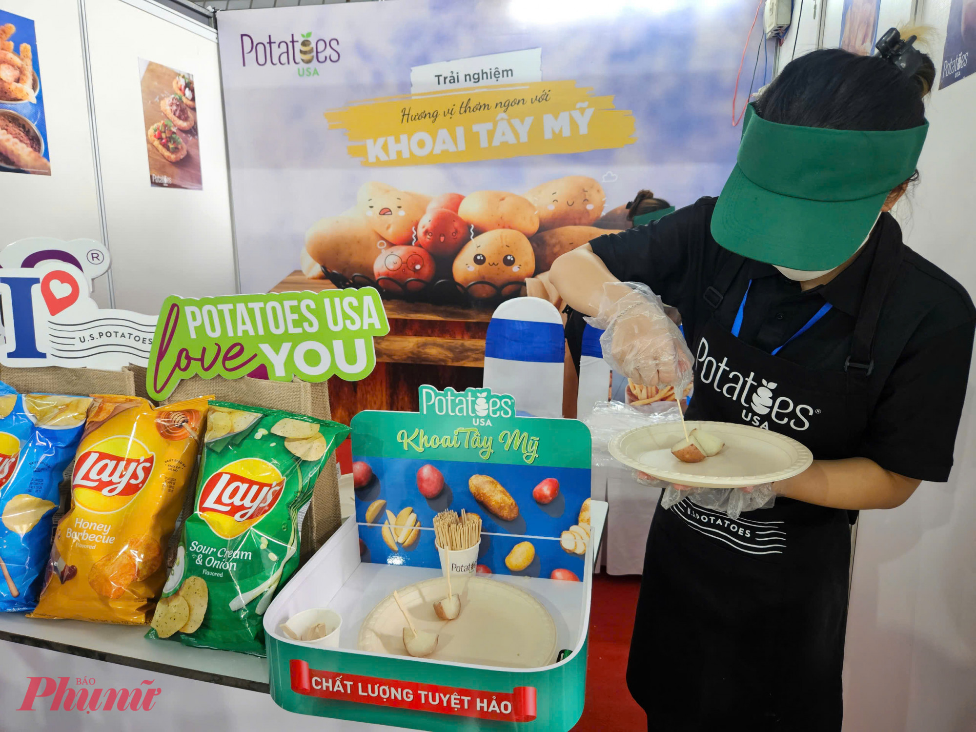 Nhân viên Potatoes USA chuẩn bị phần khoai tây hấp cắt lát dùng thử cho khách tham quan. Ngoài sản phẩm khoai tươi, các dòng khoai chế biến sẵn như chips Lay’s cũng được trưng bày.