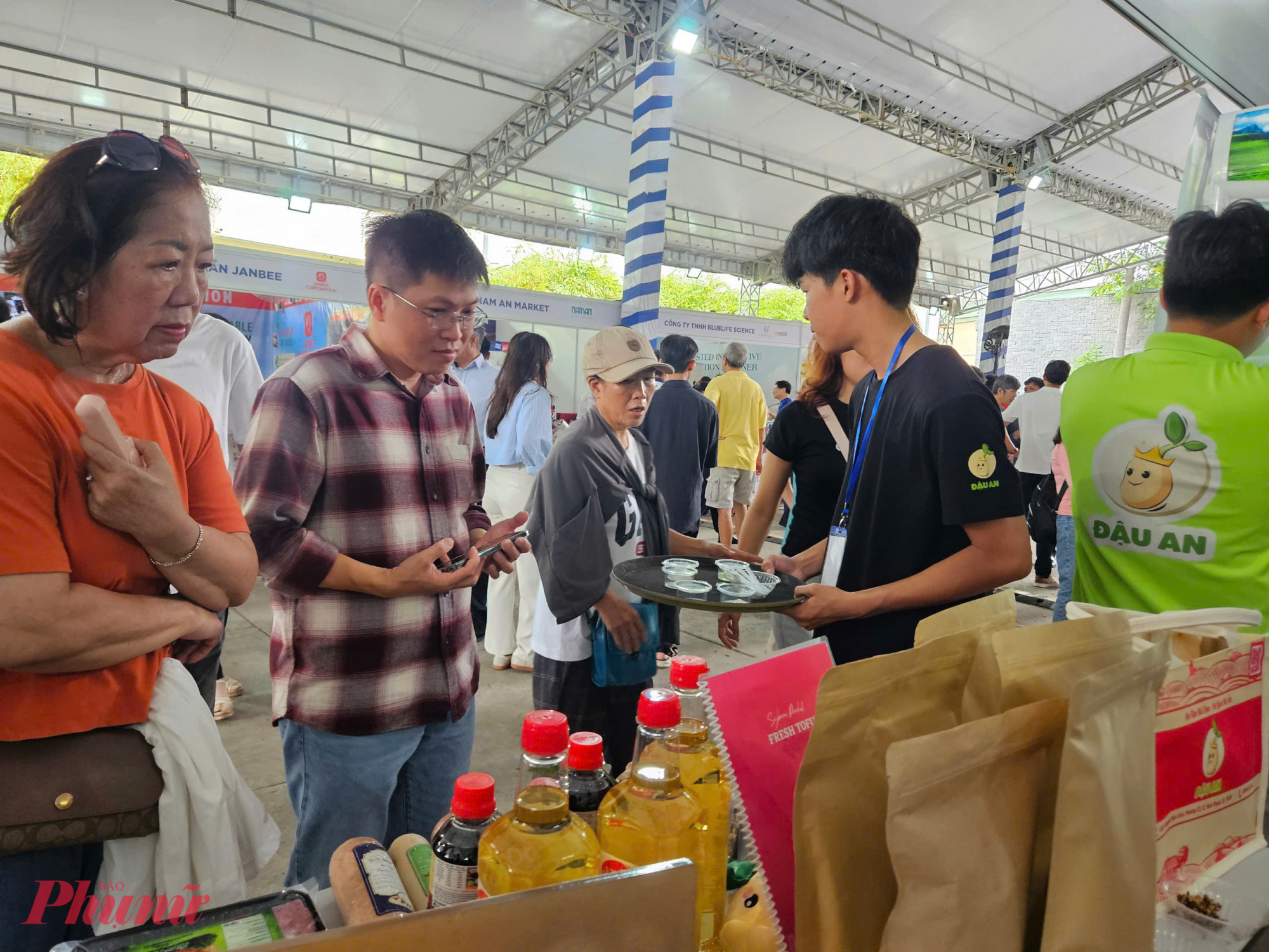 Người tiêu dùng chăm chú tìm hiểu thông tin sản phẩm tại gian hàng trưng bày dầu ăn, xúc xích, giò nguội… Nhiều sản phẩm được nhập khẩu từ Mỹ và phân phối bởi doanh nghiệp Việt.