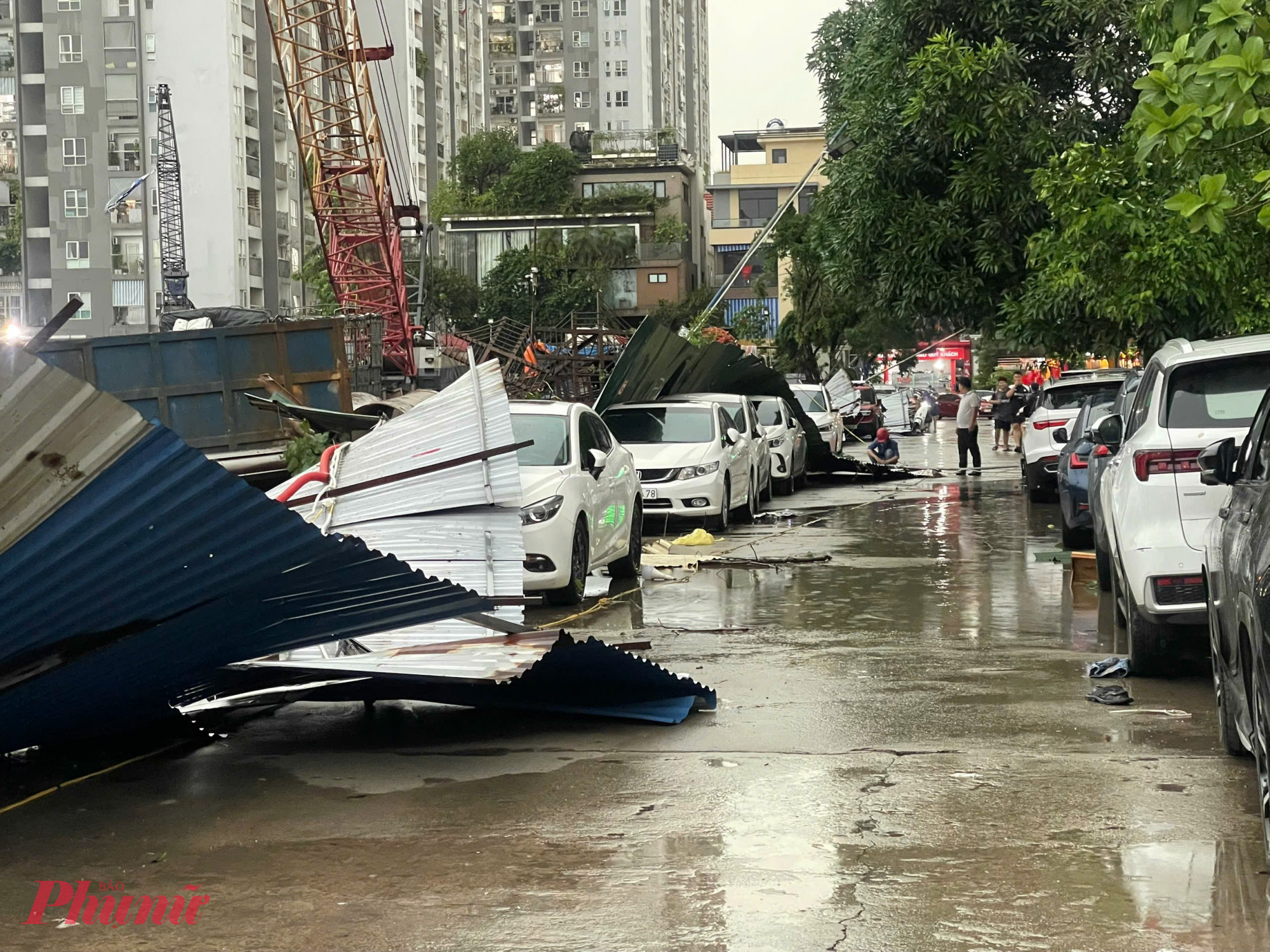 Hàng rào tôn tại một công trình xây dựng trên đường Nghiêm Xuân Yêm (phường Định Công, Hà Nội) bị đổ, đè lên khoảng 4 ô tô đỗ trong đường nội khu, khu đô thị Kim Văn Kim Lũ.