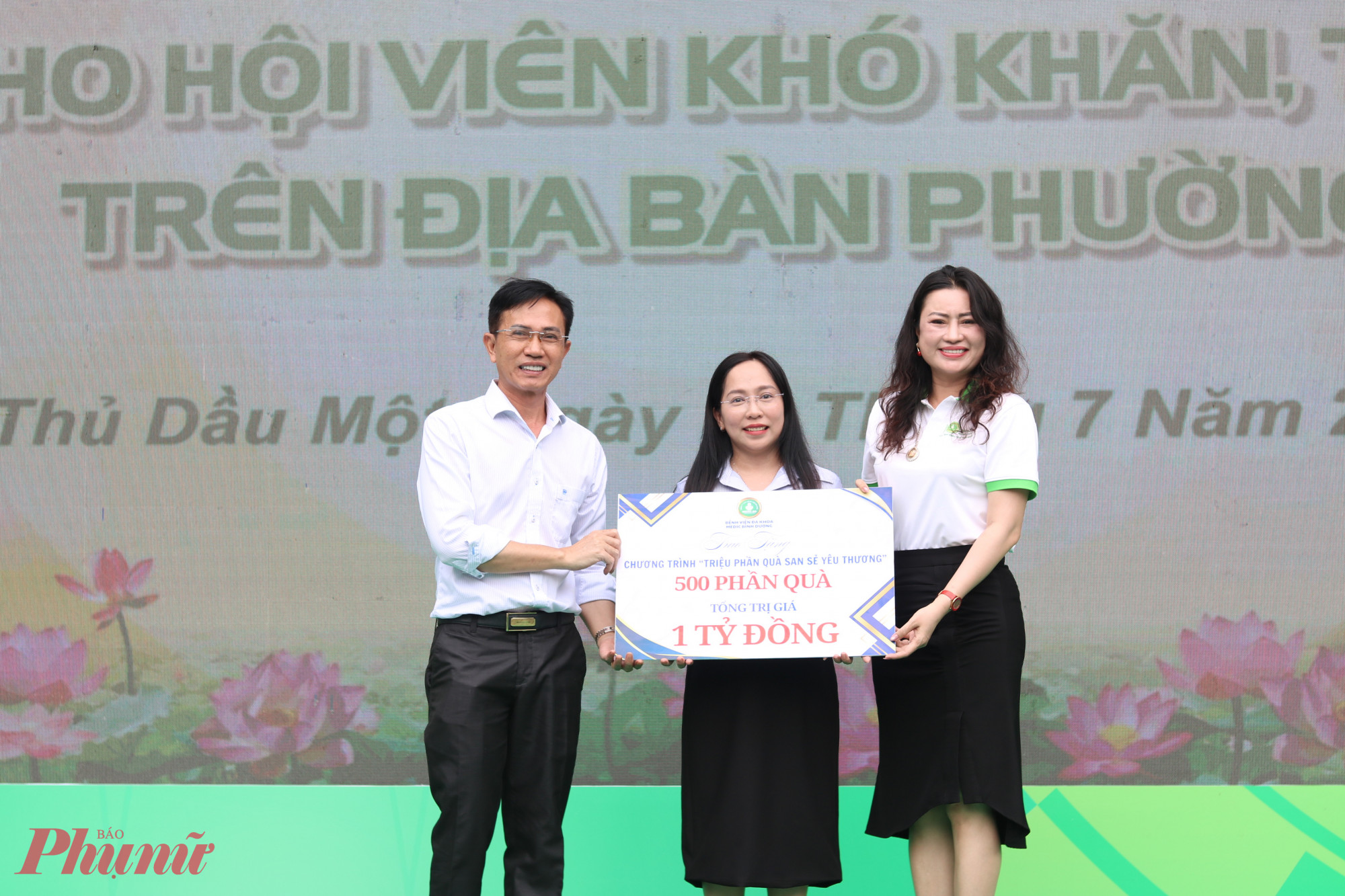 Bà Lê Thị Thuý Hà (giữa) – Phó chủ tịch Uỷ ban MTTQ, Chủ tịch Hội LHPN phường Thủ Dầu Một nhận bảng tượng trưng gói hỗ trợ thực hiện chương trình “Triệu phần quà san sẻ yêu thương” từ đại diện Bệnh viện đa khoa Medic Bình Dương.