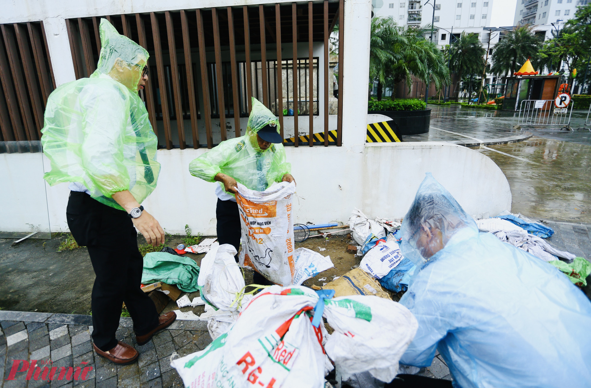 Trong chiều 21/7, nhiều người dân tại Hà Nội gia cố bao cát, chằng buộc cửa chống gió lớn, nước tràn. 