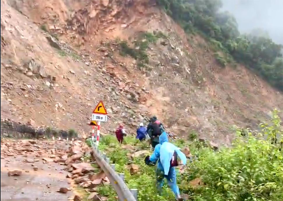 Người dân phải đi ngoài lề đường để tránh đá rơi, văng trúng vào người - Ảnh: Khánh Trung