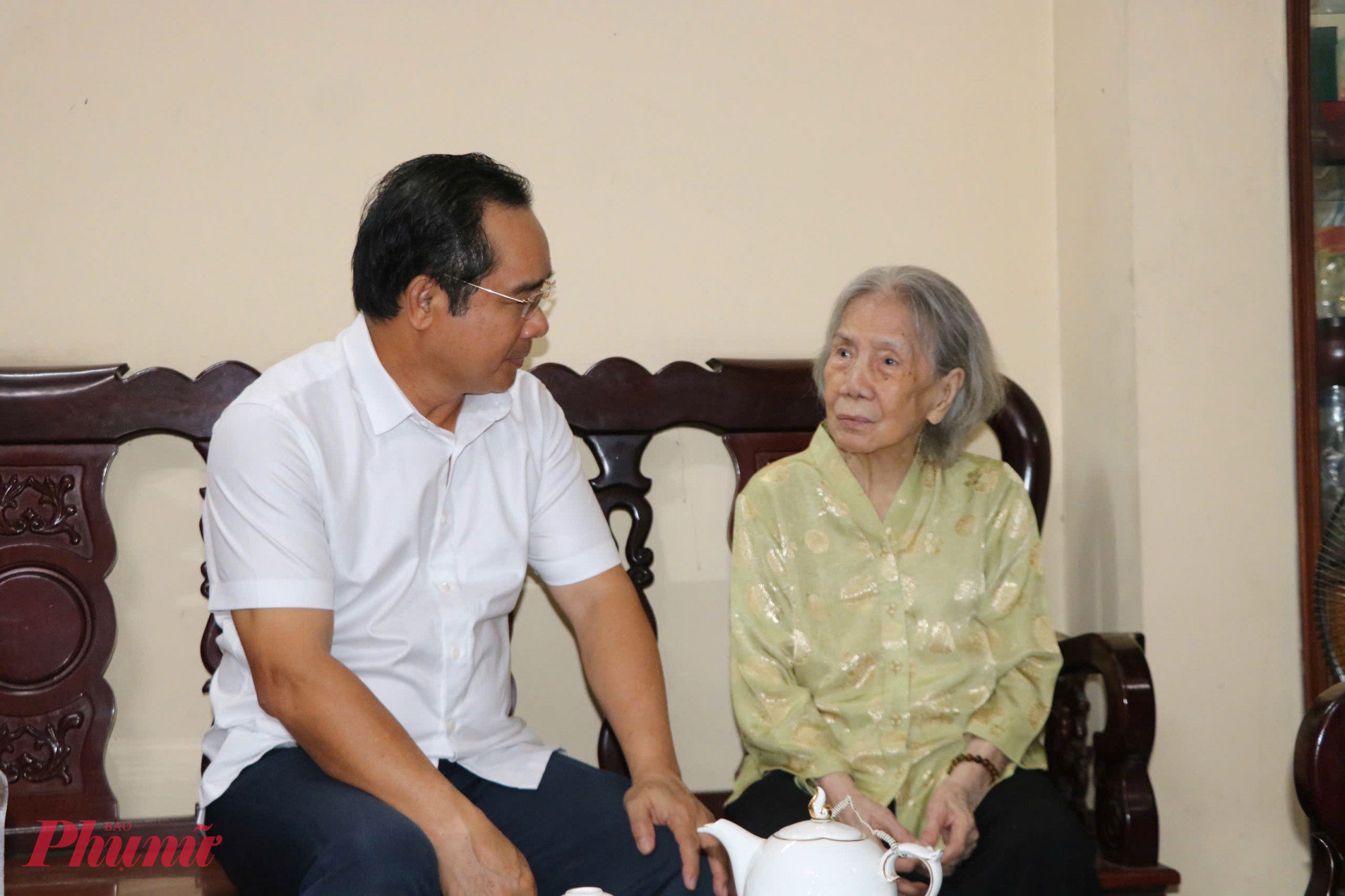 Chủ tịch UBND TPHCM Nguyễn Văn Được ân cần thăm hỏi sức khỏe bà Phạm Thị Chinh - Ảnh: Thanh Tâm