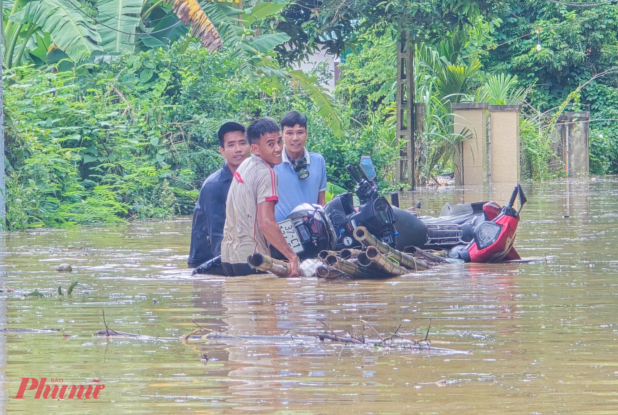 Để vớt vát tài sản, nhiều người dầm mình ở mực nước ngang cổ để đưa tài sản, vật nuôi đến nơi cao ráo.