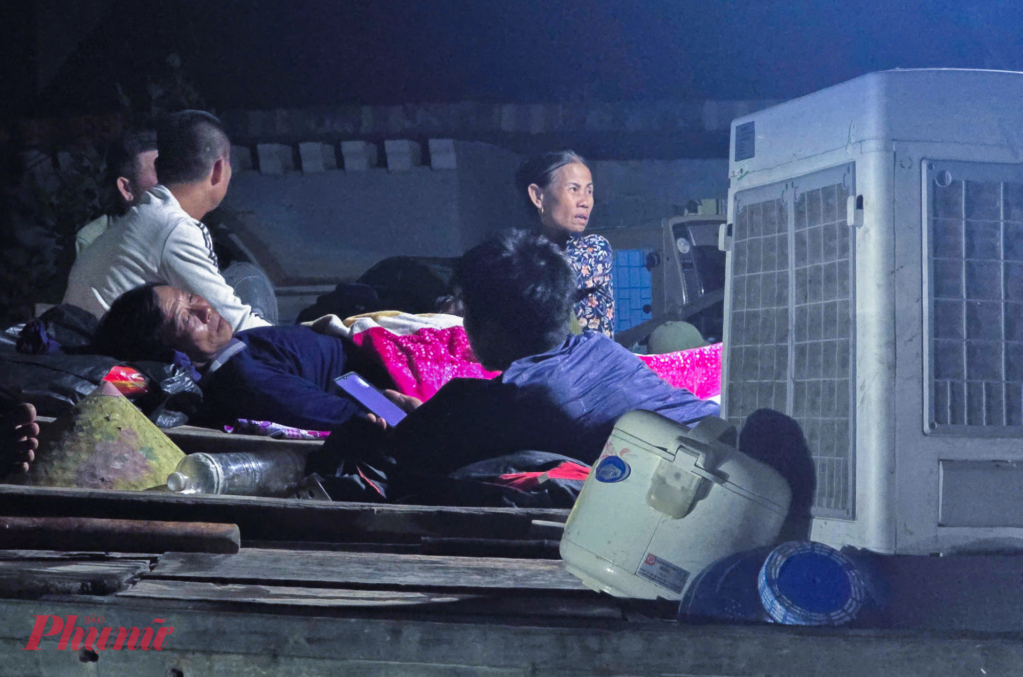 Sau một ngày đêm chạy lũ, họ tranh thủ chợp mắt ngay trên thuyền. Bên cạnh là những đồ dùng điện tử di dời được trước khi nước lũ tràn vào nhà.