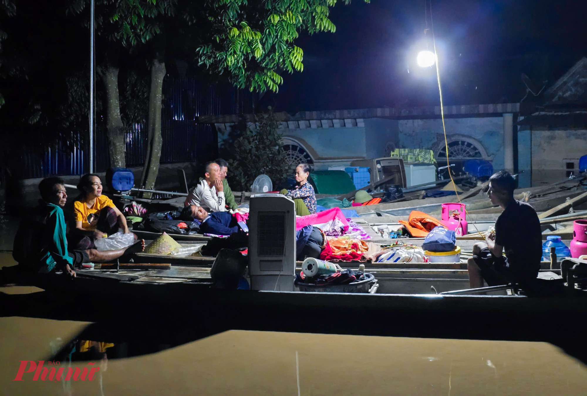 Bên những căn nhà đã ngập quá nửa, nhiều người tranh thủ chợp mắt ngay trên thuyền để chờ nước rút. Phần lớn nhà của họ đều ở mép sông Lam nên bị ngập sâu 2-3m, một số căn nhà hiện đã đổ sập hoàn toàn xuống sông.