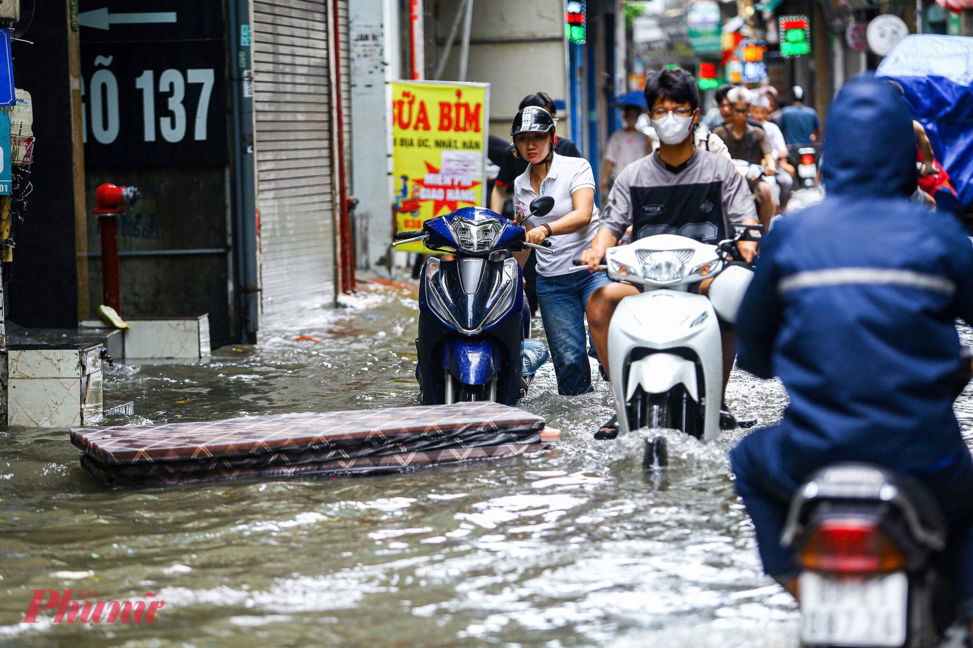 Tại “điểm đen” ngập úng phố Triều Khúc,  sau trận mưa lớn, khu vực này chưa kịp thoát nước, người dân phải lội bì bõm đi lại