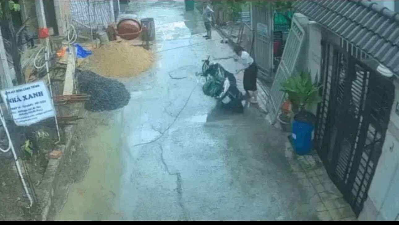 Dù xe vẫn lui qua được nhưng người phụ nữ vẫn quay lại xô đổ chiécxa máy. Ảnh cắt từ clip