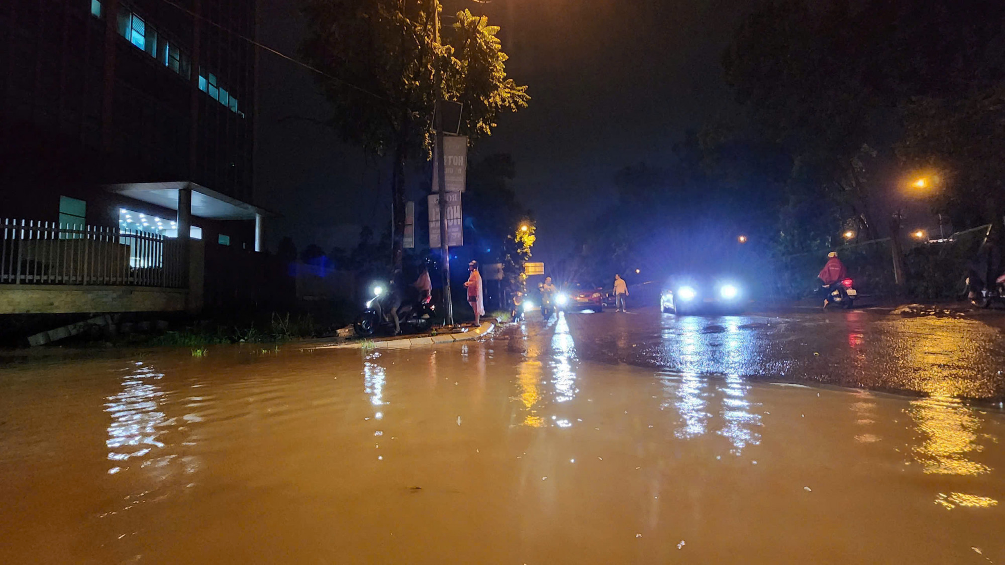 Trên đại lộ Thăng Long, nước ngập tràn mặt đường, các phương tiện phải men theo mép đường để di chuyển.