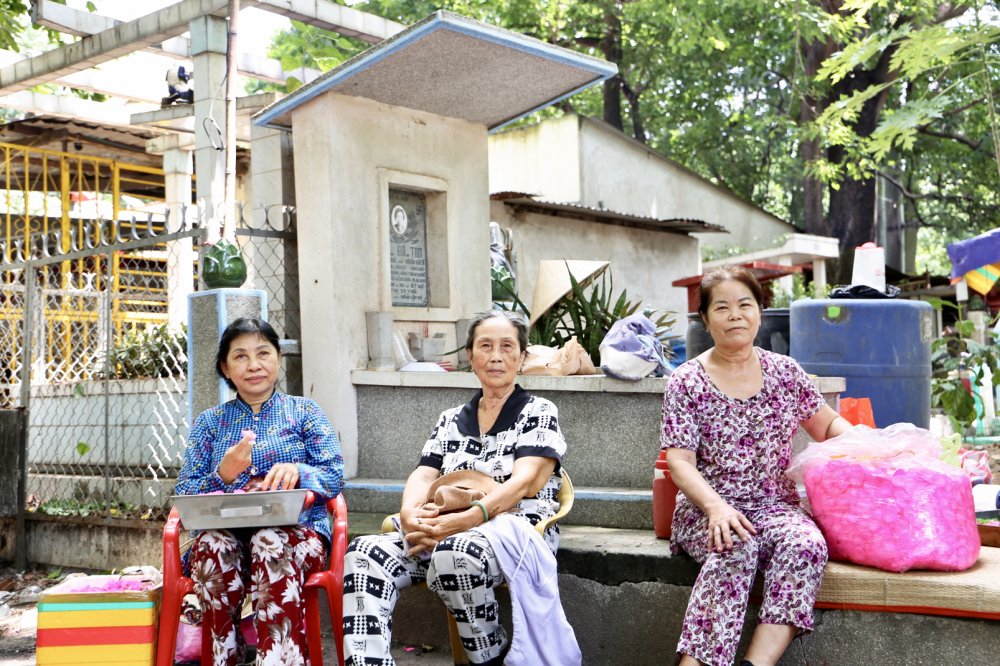 Sự sống hồi sinh trên “đất chết” Bình Hưng Hòa Bà Đinh Kim Ngọc (thứ nhất từ trái sang) cùng các chị em ngồi đan hoa nhựa thủ công trong nghĩa trang Bình Hưng Hòa - ẢNH: THANH TÂM
