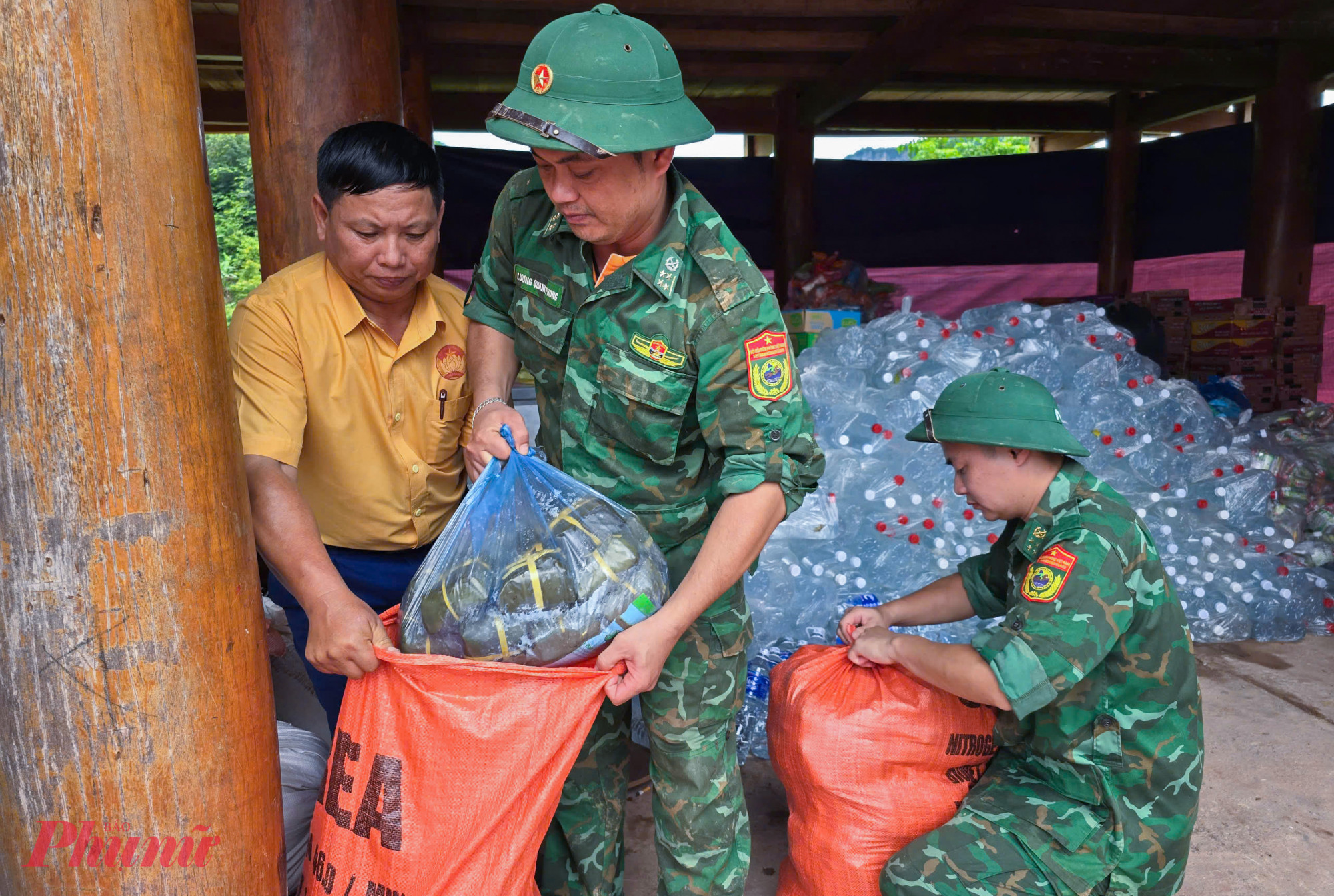 Chiến sĩ Đồn biên phòng Mỹ Lý mang bánh chưng, nước sạch cứu trợ đến cho người dân
