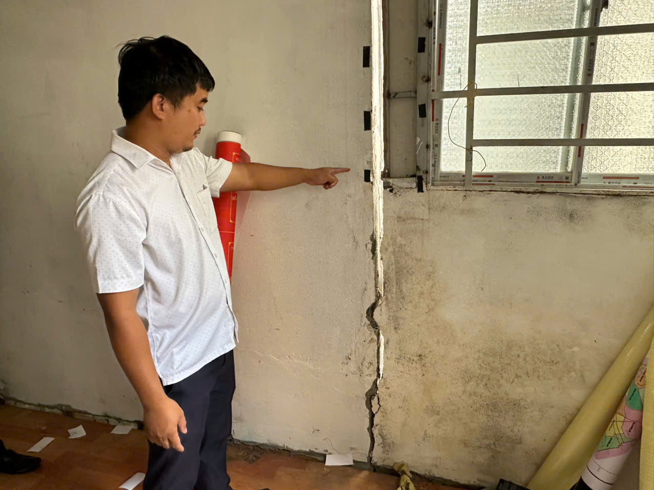 Anh Sơn chỉ các vết nứt trên tường nhà. Ảnh: Minh Mẫn.