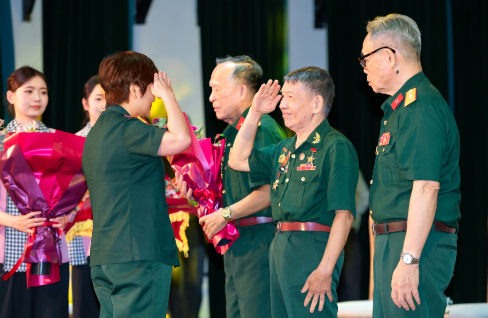 Cựu binh Nguyễn Văn Hợi chào đại tá Kiều Thanh Thúy - Giám đốc sản xuất phim Mưa đỏ