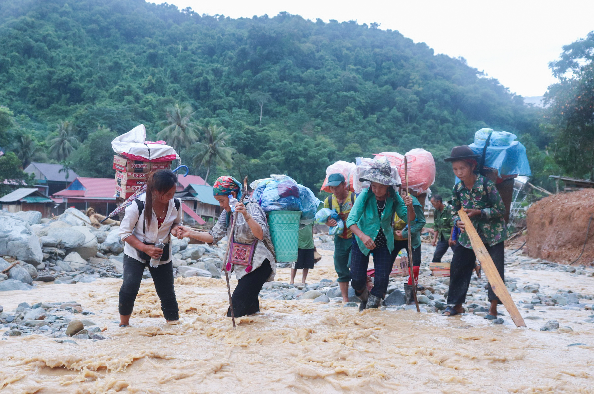 Người dân các bản bị cô lập ở xã Nhôn Mai gùi hàng cứu trợ về nhà - Ảnh: Lam Viết