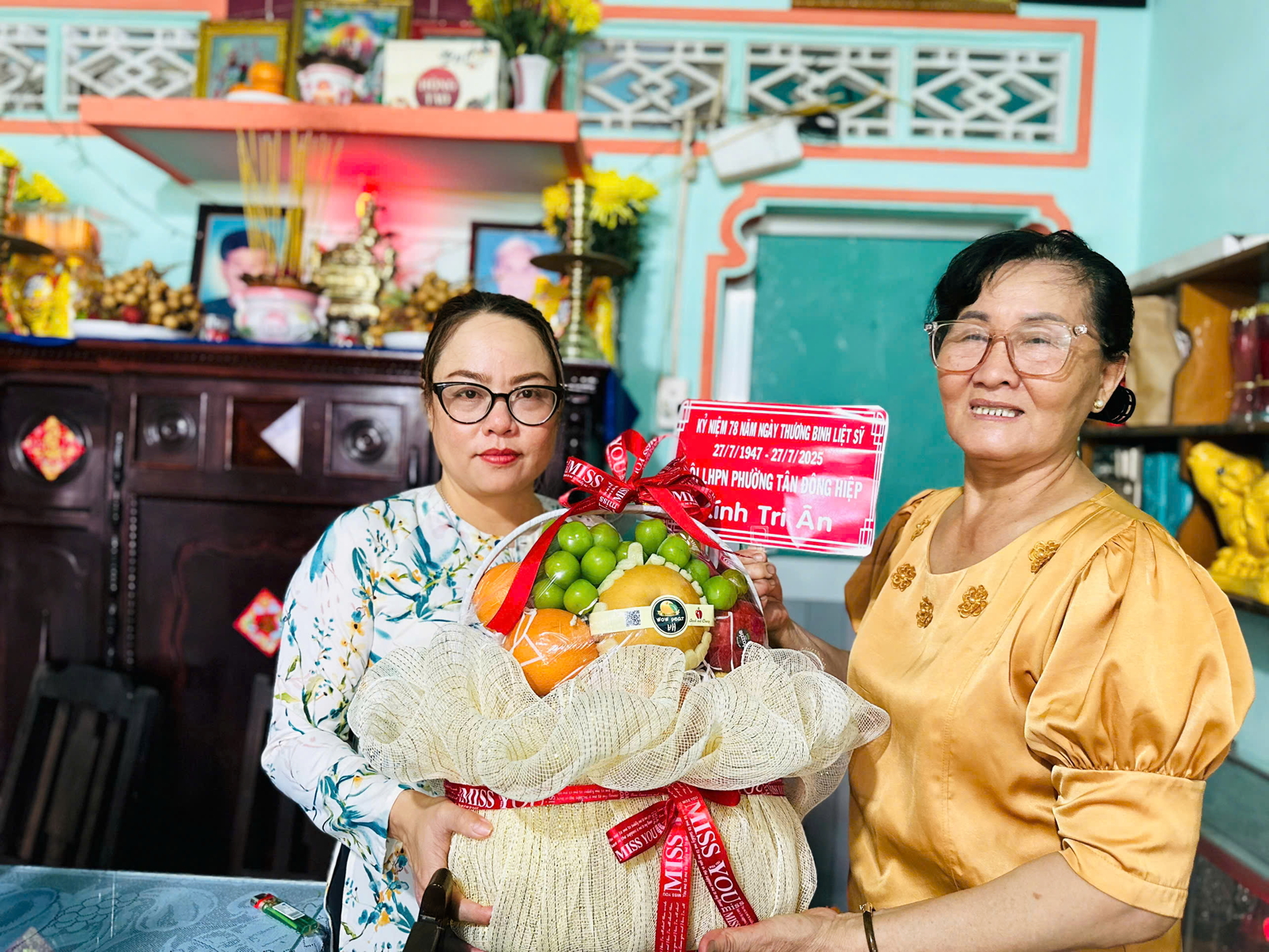 Bà Chu Thị Thanh Thủy (bìa trái) - Chủ tịch Hội LHPN phường Tân Đông Hiệp - tặng quà cho con gái  của Mẹ Việt Nam anh hùng Nguyễn Thị Phe