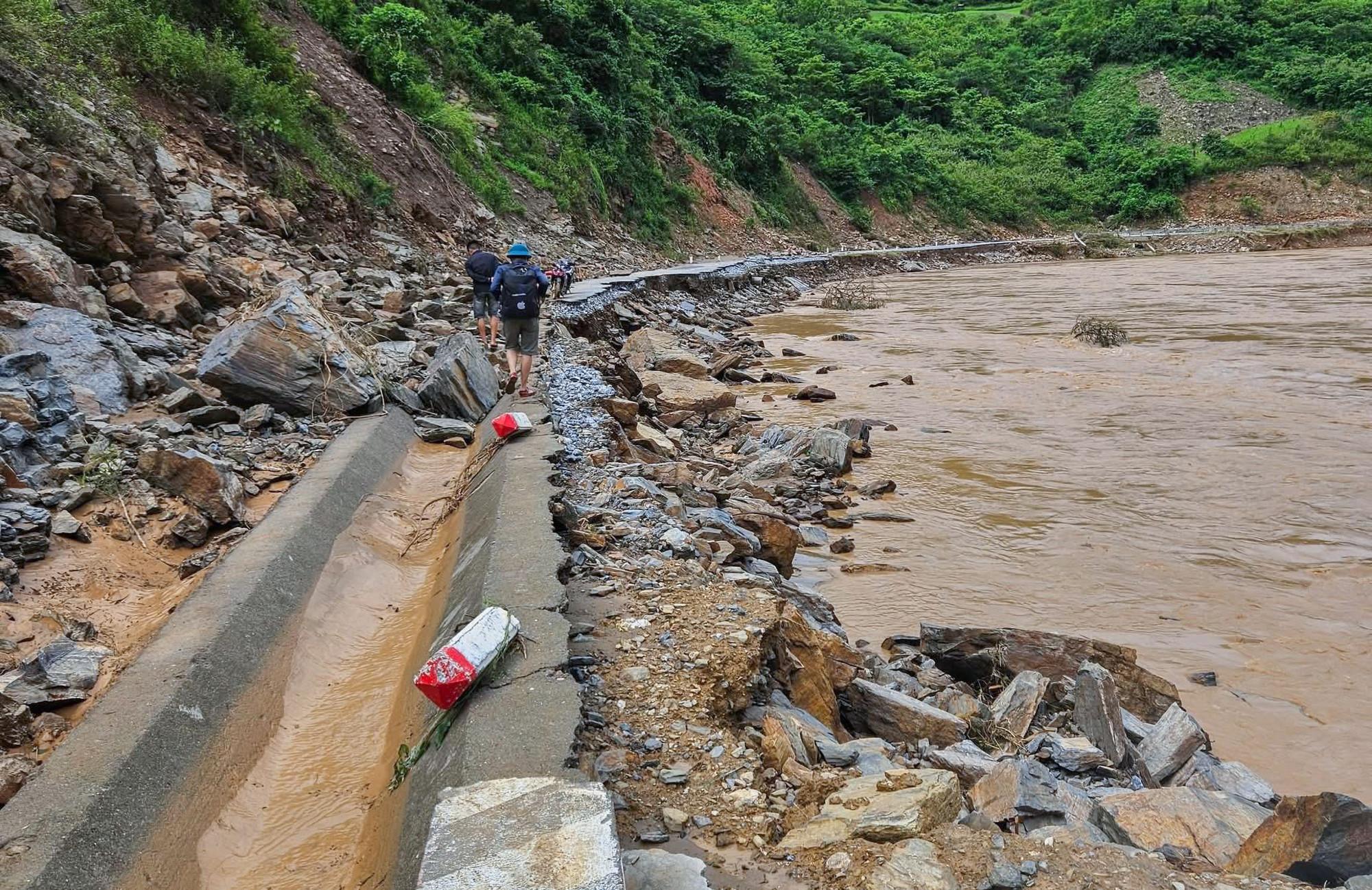 Tỉnh lộ 543D đi vào xã biên giới Mường Típ (tỉnh Nghệ An) bị lũ cuốn trôi nham nhở. Bà Vi Thị Quyên - Bí thư xã Mường Típ - cho biết, riêng khoảng 3km gần UBND xã đã có 20 vị trí bị sạt lở và đứt đường nghiêm trọng. Hiện các lực lượng chức năng đang nỗ lực khơi thông một vệt sát chân núi để xe máy có thể đi qua lại - Ảnh: Hoàng An