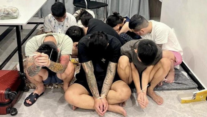 Các nghi phạm được nhìn thấy với hai tay bị buộc dây sau khi bị bắt giữ trong một cuộc đột kích của cảnh sát vào một trung tâm lừa đảo ở Phnom Penh, Campuchia, vào ngày 16 tháng 7.
